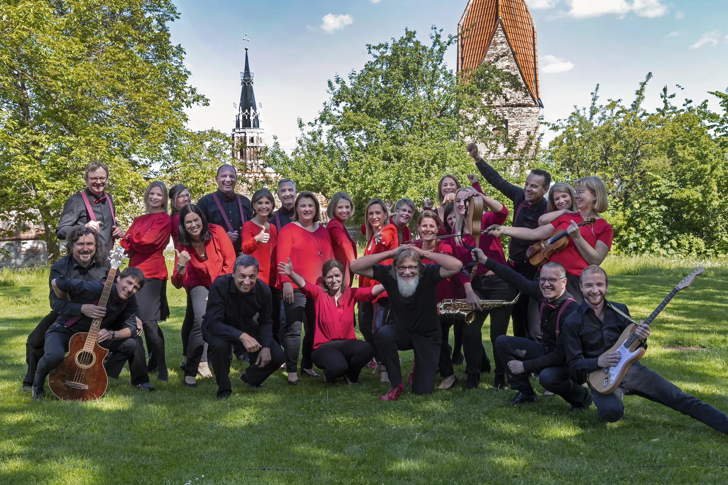 Die ganze Truppe von friends for music ausgelassen auf einer Wiese, im Hintergrund die Türme von Landshut